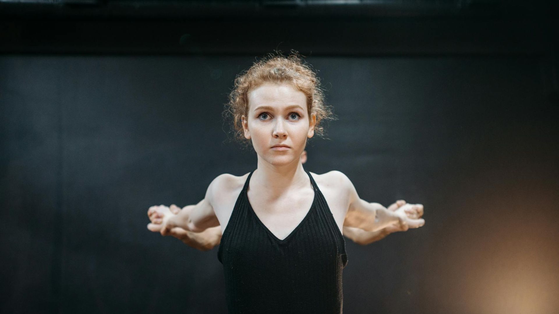 A calm and focused person practicing a mindful movement in a minimalist space.